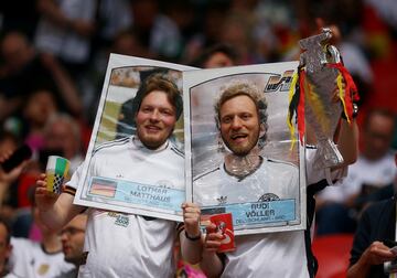 La Eurocopa 2024 dio ayer el pistoletazo de salida en Múnich con el partido entre la anfitriona, Alemania, y Escocia. Dos aficionados de la Mannschaft posan en las gradas del Múnich Arena con unos originales cromos, a tamaño natural, de los exjugadores Lothar Matthäus y Rudi Völler donde se ven las caras de los propios aficionados.  