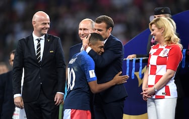 El presidente francés, Emmanuel Macron abraza y otorga a Kylian Mbappé el Premio al Jugador Joven de la FIFA. Tras ellos el presidente de Rusia, Vladimir Putin, y la presidenta de Croacia, Kolinda Grabar Kitarovic. La fotografía fue tomada durante la final del Mundial de 2018.