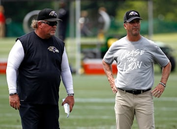 El coordinador defensivo Don Martindale y el head coach John Harbraugh viendo el inicio del entrenamiento en las instalaciones del equipo.