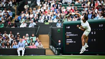 Spain's Carlos Alcaraz serves the ball to France's Jeremy Chardy  during their men's singles tennis match on the second day of the 2023 Wimbledon Championships at The All England Tennis Club in Wimbledon, southwest London, on July 4, 2023. (Photo by SEBASTIEN BOZON / AFP) / RESTRICTED TO EDITORIAL USE
