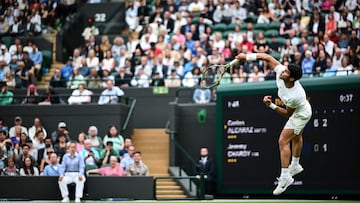 Spain's Carlos Alcaraz serves the ball to France's Jeremy Chardy  during their men's singles tennis match on the second day of the 2023 Wimbledon Championships at The All England Tennis Club in Wimbledon, southwest London, on July 4, 2023. (Photo by SEBASTIEN BOZON / AFP) / RESTRICTED TO EDITORIAL USE