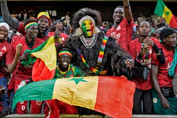 Senegal se enfrent¨® a Togo en las eliminatorias de ?frica de clasificaci¨®n para el Mundial 2026, donde logr¨® una c¨®moda victoria por 2-0. La afici¨®n senegalesa aprovech¨® que el partido se jugaba en casa, en el Abdoulaye Wade, en Diamniadio, para llenar las gradas del estadio. En la imagen, un grupo de seguidores con los colores de su pa¨ªs disfrutan del encuentro.