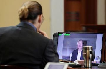 Actor Johnny Depp listens as his former girlfriend, Model Kate Moss testifies via video link during Depp's defamation trial against his ex-wife Amber Heard.