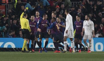 Los jugadores del Barcelona celebrando el gol de Malcom y Mateu Lahoz sacando tarjeta amarilla a Jordi Alba