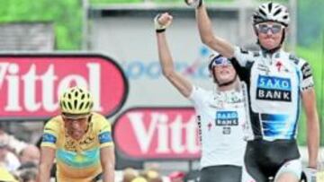 <b>UN CAMPEÓN Y DOS COLOSOS. </b>Frank Schleck cruza la meta vencedor mientras Andy, su hermano pequeño, celebra también la victoria. Contador, a su lado, afligido.