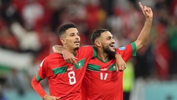 Morocco's midfielder #08 Azzedine Ounahi (L) and Morocco's midfielder #17 Sofiane Boufal celebrate with supporters after they won the Qatar 2022 World Cup quarter-final football match between Morocco and Portugal at the Al-Thumama Stadium in Doha on December 10, 2022. (Photo by KARIM JAAFAR / AFP)