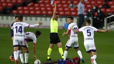 Referee Santiago Jaime Latre shows a red card to Valladolid's Oscar Plano after he tackled Barcelona's Ousmane Dembele during the Spanish La Liga soccer match between FC Barcelona and Valladolid CF at the Camp Nou stadium in Barcelona, Spain, Mo