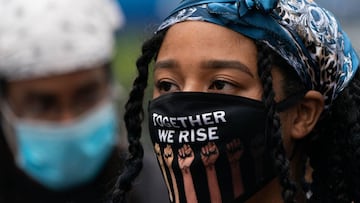 &quot;Together we rise&quot; is written on the mouth and nose protection of a demonstrator during a Black Lives Matter protest in the Harlem neighborhood of New York City.