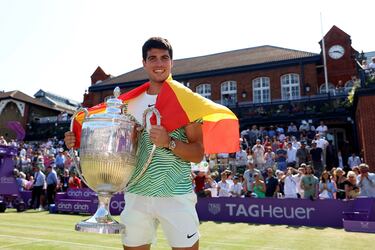 Alcaraz posa con el trofeo para la prensa ataviado con la bandera española.
