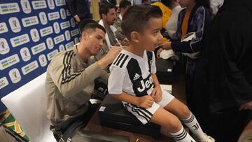 Cristiano firma la camiseta de un niño saudí.