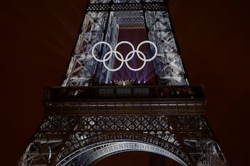 La estrella canadiense, Celine Dion, actúa en la Torre Eiffel en medio de un espectáculo de luces que salen de la imponente estructura con los anillos olímpicos  iluminados.