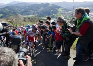 Varios ciclistas se abren paso entre la gente hoy en el Alto de La Antigua, en la localidad guipuzcoana de Zumarraga, durante la tercera etapa de la 55 edición de la Vuelta al País Vasco.