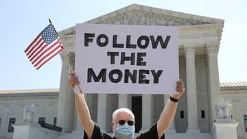 Bill Christeson holds a sign reading "follow the money" in anticipation of justices ruling on U.S. President Donald Trump's bid to block his financial records from being obtained by third parties, outside the U.S. Supreme Court in Washington, U.S., July 8, 2020. REUTERS/Jonathan Ernst TPX IMAGES OF THE DAY