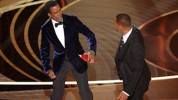 Chris Rock reacts after being hit by Will Smith (R) as Rock spoke on stage during the 94th Academy Awards in Hollywood, Los Angeles, California, U.S., March 27, 2022. REUTERS/Brian Snyder