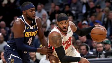 Paul Millsap trata de frenar el avance de Carmelo Anthony.