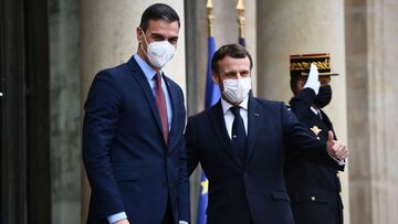 French President Emmanuel Macron (R) welcomes Spanish Prime minister Pedro Sanchez prior to a meeting marking the 60th anniversary of the creation of the Organisation for Economic Co-operation and Development (OECD) at the Elysee palace in Paris on December 14, 2020. (Photo by Martin BUREAU / POOL / AFP)