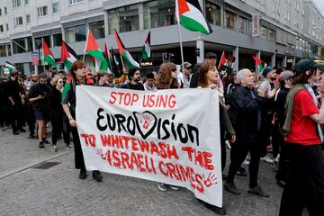 Los manifestantes llevan una pancarta y banderas palestinas durante una protesta contra la participación israelí en el Festival de la Canción de Eurovisión.