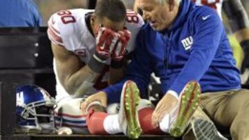 Victor Cruz se tapa la cara asustado por la lesión que acaba de sufrir.