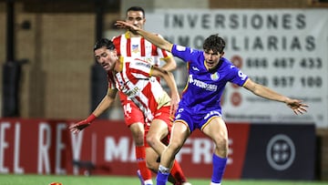 NAVALCARNERO, 02/12/2025.- El defensa del Navalcarnero João Gil Dias (i) lucha con Mario Martín, del Getafe, durante el encuentro correspondiente a la segunda eliminatoria de la Copa del Rey que Navalcarnero y Getafe disputan hoy martes en el estadio Mariano García, en la localidad madrileña. EFE / Victor Lerena.