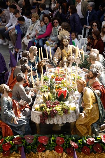 Varias personas observan un trono de 'La Última Cena', durante la procesión de Los Salzillos de la Real y Muy Ilustre Cofradía de Nuestro Padre Jesús Nazareno el Viernes Santo en Murcia, Región de Murcia (España).