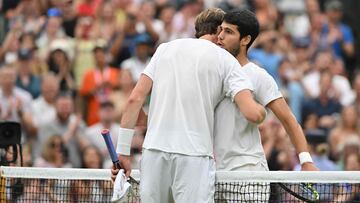 Spain's Carlos Alcaraz (R) and Chile's Nicolas Jarry hug each other after their men's singles tennis match on the sixth day of the 2023 Wimbledon Championships at The All England Tennis Club in Wimbledon, southwest London, on July 8, 2023. (Photo by Glyn KIRK / AFP) / RESTRICTED TO EDITORIAL USE