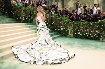 La modelo, Gigi Hadid, posa con un vestido blanco y flores amarillas del diseñador Thom Browne.
