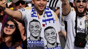 Supporters wearing football scarves depicting French footballer Kylian Mbappe cheer prior Real Madrid's celebration