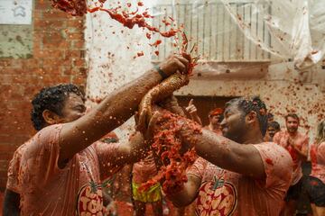BUNOL, SPAIN - AUGUST 30: Revellers enjoy the atmosphere in tomato pulp while participating the annual Tomatina festival on August 30, 2017 in Bunol, Spain. An estimated 22,000 people threw 150 tons of ripe tomatoes in the world's biggest tomato fight held annually in this Spanish Mediterranean town. (Photo by Pablo Blazquez Dominguez/Getty Images)