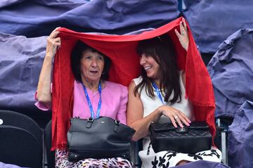 Dos espectadoras se refugian de la lluvia bajo un chal mientras se retrasa el partido de tenis entre el tenista serbio y el número cuatro del mundo, Novak Djokovic y el canadiense Vasek Pospisol en el torneo internacional de tenis ATP Aegon en Eastbourne, al sur de Inglaterra.