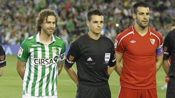 El árbitro Carlos del Cerro Grande posa junto a los capitanes de Real Betis y Sevilla FC antes de un derbi sevillano.