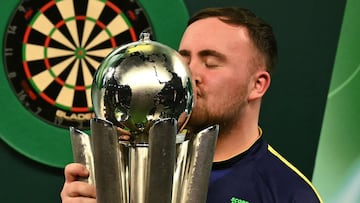 England's Luke Littler kisses the Sid Waddell Trophy after victory over Netherlands' Michael van Gerwen in the PDC World Darts Championship final, at Alexandra Palace in London on January 3, 2025. Luke Littler became darts' youngest world champion at just 17 after thrashing three-time winner Michael van Gerwen in front of an adoring home crowd at London's Alexandra Palace on Friday. This time there was no stopping "Luke the Nuke" as he stormed past Dutchman Van Gerwen by seven sets to three. (Photo by Ben STANSALL / AFP)