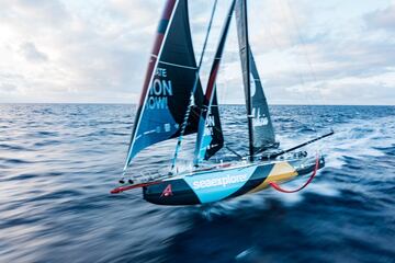 El velero Malizia de la clase IMOCA, navegando sobre uno de sus hidrofoils rojo.