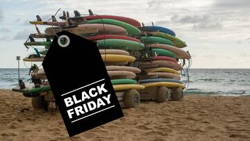 Etiqueta negra con las letras Black Friday -el d&iacute;a de m&uacute;ltiples ofertas y descuentos de tiendas y marcas- en blanco sobre dos carros con m&uacute;ltiples tabla de surf para principiantes. 