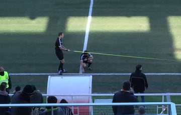 Los árbitros mirando las distancias del terreno de juego.