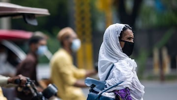 A woman waits for the light to cross a street in New Delhi on August 1, 2020. (Photo by Jewel SAMAD / AFP)