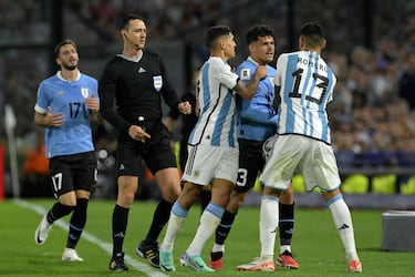 El mediocampista uruguayo Maximiliano Araujo (atrs) y el defensor argentino Cristian Romero (derecha) discuten durante el partido.