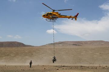 Un helicóptero transporta la moto del piloto francés Charlie Herbst.