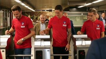 Saúl, Torres y Griezmann pasando los tornos del Metro.