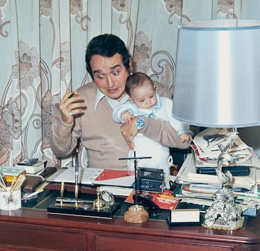 El actor y comediante español Fernando Esteso sostiene a su bebé y hace una mueca, Madrid, España, 1974.