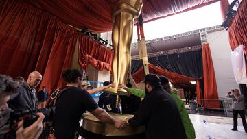 Workers load in a large Oscar statue as preparations continue for the 95th Academy Awards.