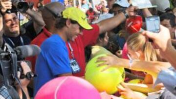 Rafa Nadal, siempre sonriente, firma autógrafos después de un entrenamiento.