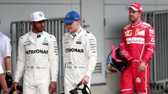 Mercedes&#039; British driver Lewis Hamilton (L), who gained pole position, walks to the podium with second placed Mercedes&#039; Finnish driver Valtteri Bottas (C) and third placed Ferrari&#039;s German driver Sebastian Vettel (R) following the qualifying session of the Formula One Japanese Grand Prix at Suzuka on October 7, 2017. / AFP PHOTO / Behrouz MEHRI