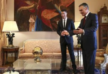 El delantero del Real Madrid y la selecci¨®n lusa, Cristiano Ronaldo le muestra al presidente del pa¨ªs, Cavaco Silva el Bal¨®n de Oro de 2013 antes de ser nombrado Gran Oficial de la Orden del Infante D. Henrique en un acto celebrado en el Palacio de Belem.