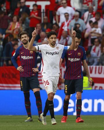 El jugador del Sevilla, Jesús Navas, celebra el 1-0 ante los jugadores del Barcelona Piqué y Busquets. 
