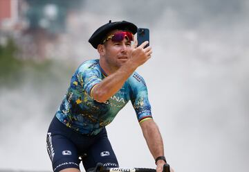 Marc Cavendish graba con su móvil la entrada de su equipo durante la presentación del Tour de Francia 2023.