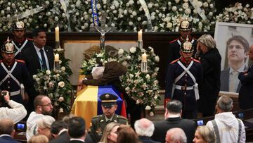 Miguel Uribe Londono, father of Colombian Senator Miguel Uribe Turbay, who died two months after he was shot in the head at a campaign event, leans over the coffin of his son during a tribute at the Colombian congress, in Bogota, Colombia August 12, 2025. REUTERS/Luisa Gonzalez