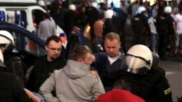 Policía antidisturbios detendiendo a un aficionado de fútbol en Varsovia, Polonia, el 12 de junio de 2012, tras el encuentro del grupo A de la Eurocopa 2012 entre Polonia y Rusia. La policía arrestó a más de 184 personas, 160 polacos y 24 rusos, tras un partido considerado de alto riesgo por la rivalidad histórica de ambos países. Varias personas resultaron heridas de carácter leve en los enfrentamientos entre aficiones, incluidos diez policías.