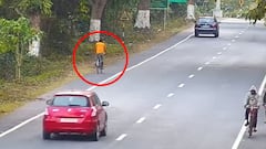 Un ciclista en el Parque nacional de Kaziranga (India), rodeado por un c&iacute;rculo rojo y con algunos coches circulando, el 16 de junio del 2022. 