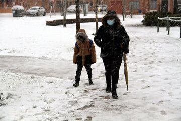 Una mujer y un niño caminan por una calle nevada este jueves en Ciudad Real donde desde las 2:30 horas se han registrado importantes precipitaciones en forma de nieve. EFE/Beldad