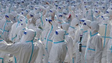 FILE PHOTO: Medical workers in protective suits wave at Changchun residents during a farewell ceremony before returning to Meihekou, where they were dispatched from to help curb the coronavirus disease (COVID-19) outbreak in Changchun, Jilin province, China April 12, 2022. China Daily via REUTERS/File Photo  ATTENTION EDITORS - THIS IMAGE WAS PROVIDED BY A THIRD PARTY. CHINA OUT.
